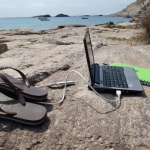 Tijd voor je werk. Laptop op het strand: overal kun je werken.